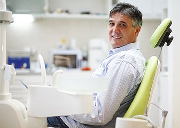 Man smiling while sitting in treatment chair