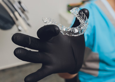 Dentist holding a new Invisalign aligner 