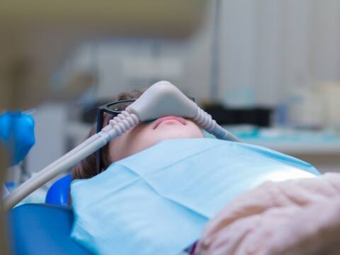 Dental patient relaxing and wearing sedation dentistry mask