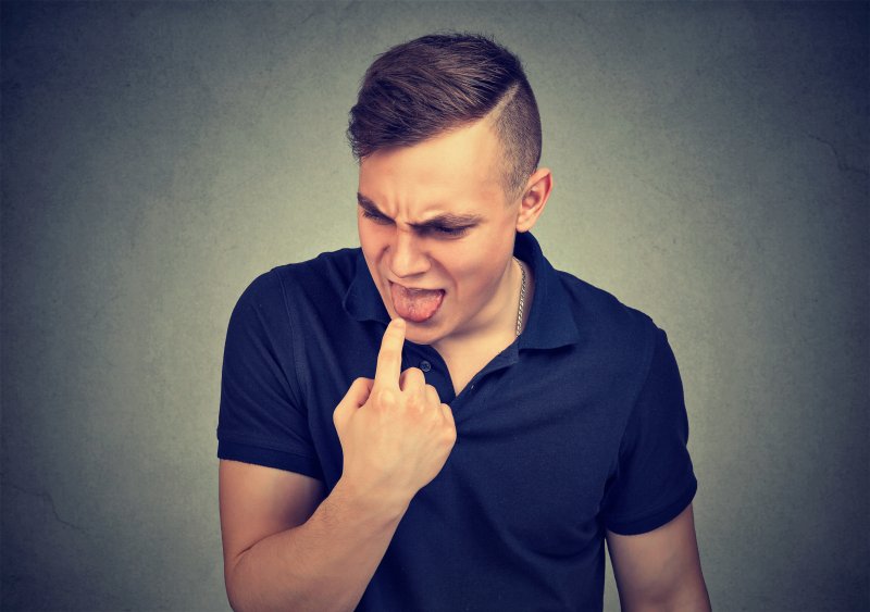 A man reacting to a bitter taste in his mouth